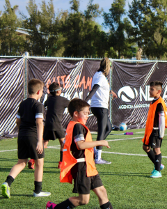 grupo de niños con uniforme negro en un campo de futbol